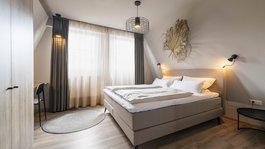 Seeblick: holidays by the lake in North Rhine-Westphalia Modern bedroom with double bed, curtains, and minimal decoration