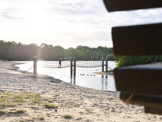 Hotel Seeblick in Gronau Kind op een hangbrug boven een meer bij zonsondergang