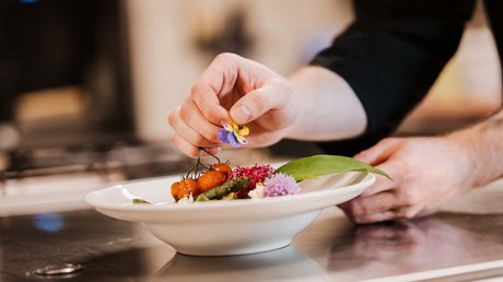 Appartementhotel Seeblick: Bildergalerie Koch dekoriert Teller mit essbarer Blume und Gemüse
