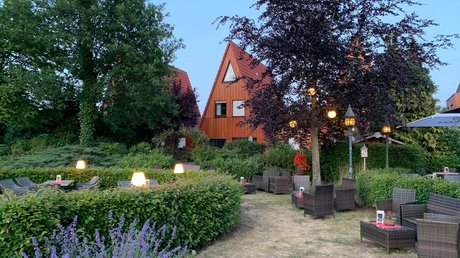 Apartment Hotel Seeblick: gallery Garden with seating and lit lanterns in front of triangular wooden houses