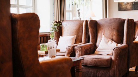 Appartementhotel Seeblick: Bildergalerie Gemütliche braune Sessel mit weißen Kissen in einem hellen Raum