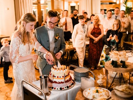 News vom Hotel direkt am See in NRW Brautpaar schneidet Hochzeitstorte vor Gästen auf einer Feier