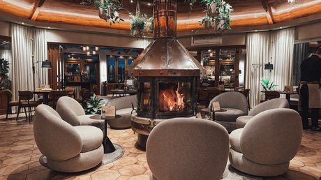 Appartementhotel Seeblick: Bildergalerie Gemütliche Sitze um einen Kamin in einem stilvollen Lounge-Bereich