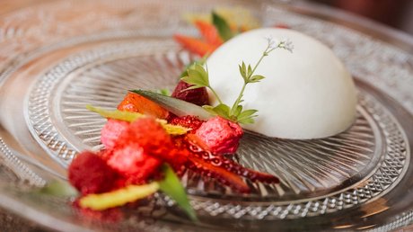 Appartementhotel Seeblick: Bildergalerie Elegantes Dessert mit weißer Creme und roten Früchten auf Glasplatte