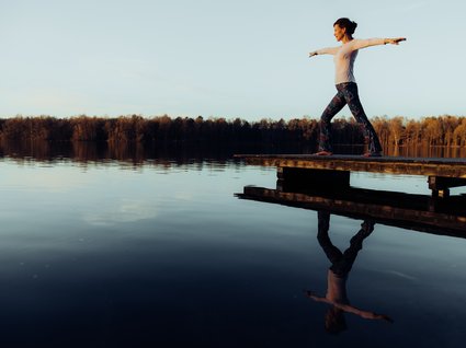 Urlaub im Apartment mit Seeblick Vrouw balanceert met uitgestrekte armen op een steiger boven een meer