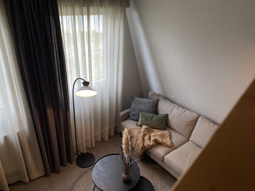 Neuer Look seit März 2023 Gemütliches Wohnzimmer mit Sofa, Stehlampe und Kaffeetisch mit Dekoration