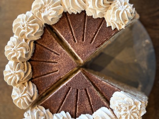 Gronau: dine with a lake view Top view of a sliced cake with whipped cream on wooden table