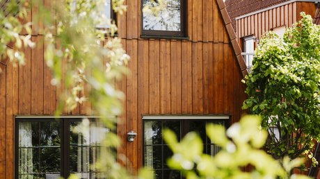 Apartment Hotel Seeblick: gallery Wooden house with large windows and green plants in the foreground