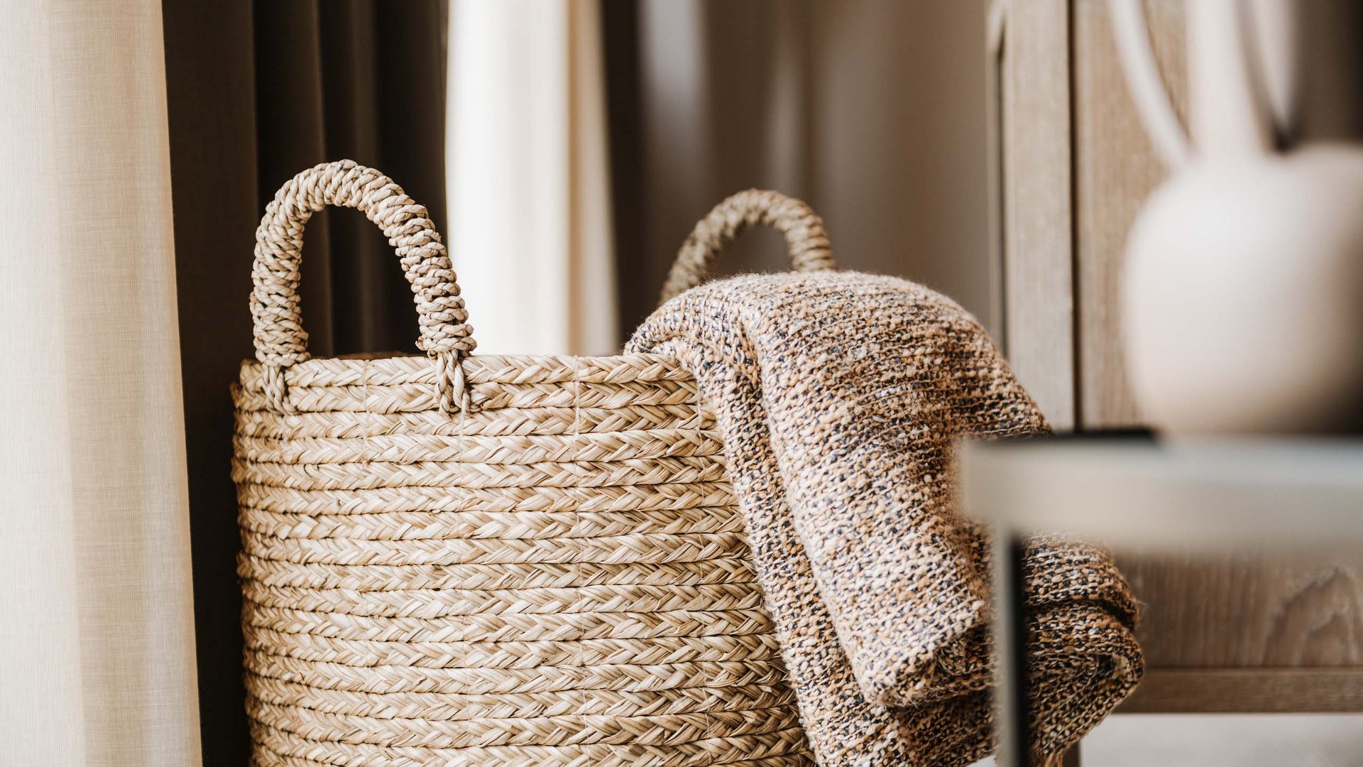 Neuer Look seit März 2023 Geflochtener Korb mit einer warmen Decke in einem gemütlichen Raum