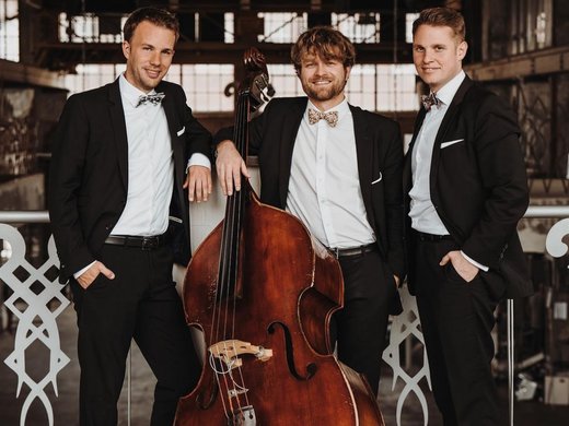 Restaurant Gronau: Seeblick Drei Männer in Anzügen posieren mit Kontrabass in einem Industriegebäude