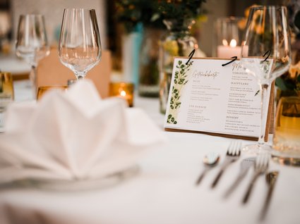 Holidays in an apartment with a lake view Elegant table setting with wine glass and menu card in the background