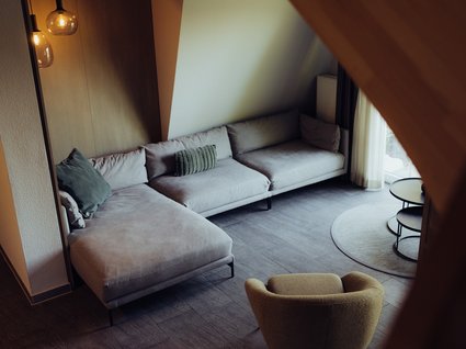 Aparthotel am See in Gronau Gemütlicher Wohnbereich mit Ecksofa, Sessel, Beistelltischen und Pendelleuchten