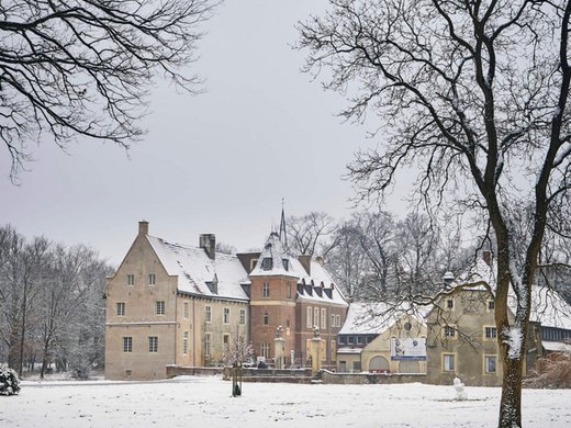 Hiking in North Rhine-Westphalia at any time of year Castle covered in snow with bare trees in winter