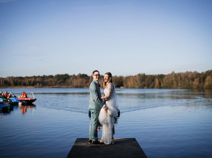 News vom Hotel direkt am See in NRW Braut und Bräutigam auf einem Steg am See bei klarem Himmel