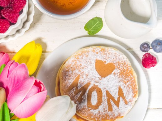 Seeblick Gronau: Urlaub inmitten der Natur Pancake mit Herz und MOM beschriftet, bunte Tulpen, Tee und Beeren auf Holz Tisch