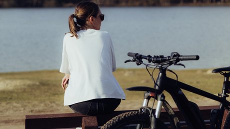 Appartementhotel Seeblick: Bildergalerie Vrouw met fiets op een bankje aan het meer