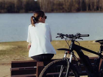 Urlaub im Apartment mit Seeblick Vrouw met fiets op een bankje aan het meer