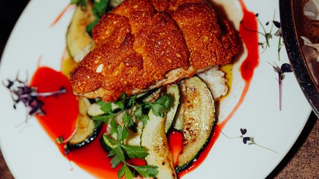Appartementhotel Seeblick: Bildergalerie Gepaneerd gerecht met gegrilde courgette, kruiden en rode saus op een bord