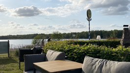 Seeblick: holidays by the lake in North Rhine-Westphalia Cozy seating area by the lakeside under a cloudy sky