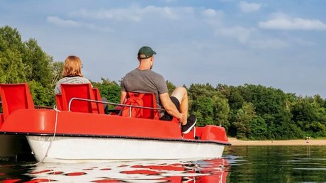 Appartementhotel Seeblick: Bildergalerie Twee personen op een rode waterfiets op een rustig meer