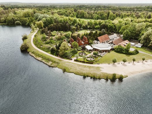 Erholung, Abenteuer und Badespaß für die ganze Familie – direkt am Dreiländersee Luchtfoto van een meer met bos en gebouwen aan een oever
