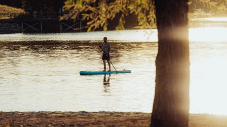 Appartementhotel Seeblick: Bildergalerie Persoon aan het paddleboarden op een rustig meer bij zonsondergang