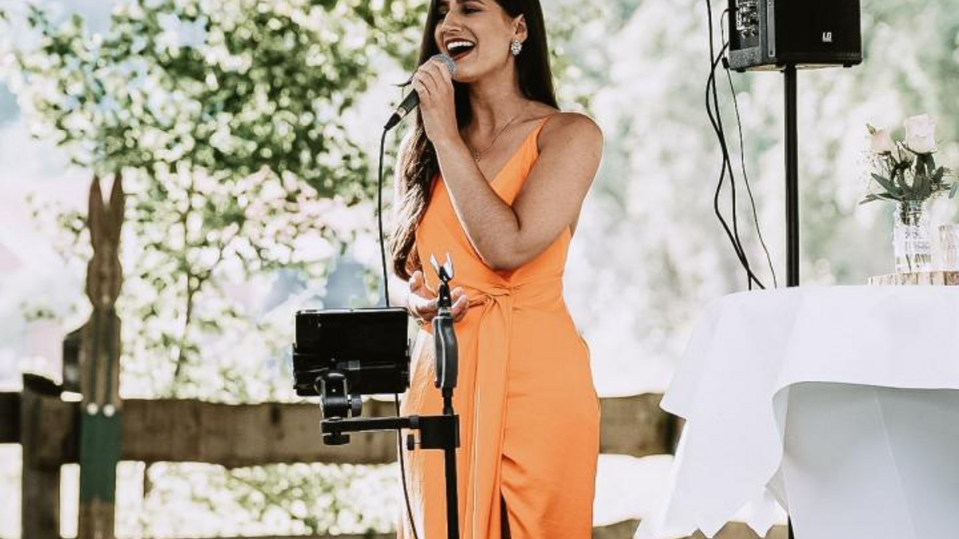 Live-Musik Event im Münsterland am See Frau singt draußen unter einem Sonnenschirm beim Event