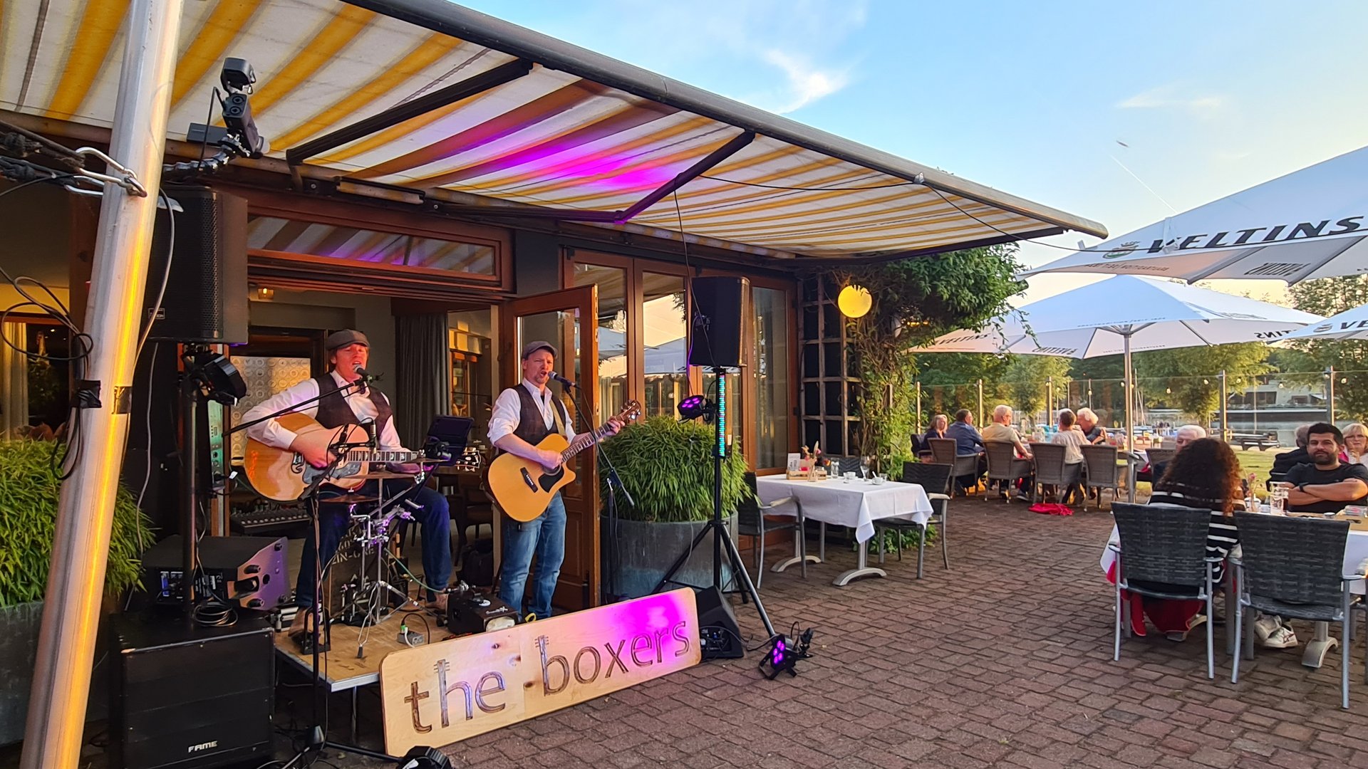 Live-Musik Event im Münsterland am See Live-Band the-boxers spielt auf Terrasse bei Sonnenuntergang vor Publikum