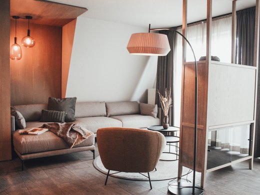 Unsere Appartements am See Modern ingerichte woonkamer met bank, fauteuil en vloerlamp