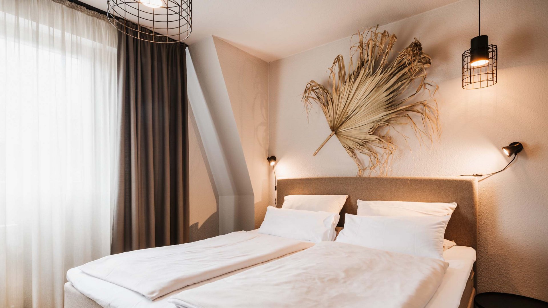 Neuer Look seit März 2023 Modernes Schlafzimmer mit Doppelbett und dekorativem getrocknetem Blatt an der Wand