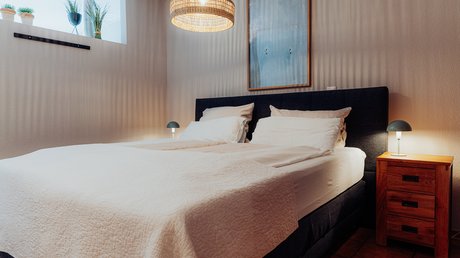 Appartementhotel Seeblick: Bildergalerie Gemütliches Schlafzimmer mit Doppelbett, Nachttisch und warmem Licht