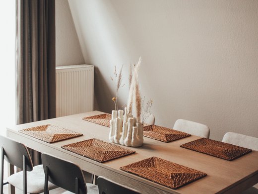 Neuer Look seit März 2023 Moderner Esstisch mit sechs Stühlen und dekorativer Vase mit Trockenblumen