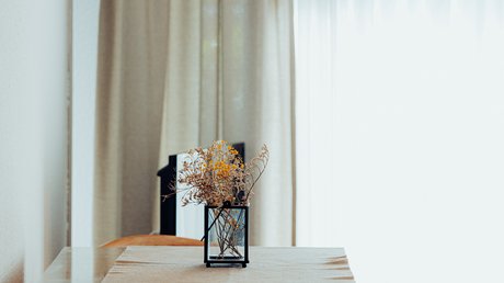 Appartementhotel Seeblick: Bildergalerie Moderner Esstisch mit Holzstuhl, blumenstrauß in Vase und Hängelampe im Hintergrund