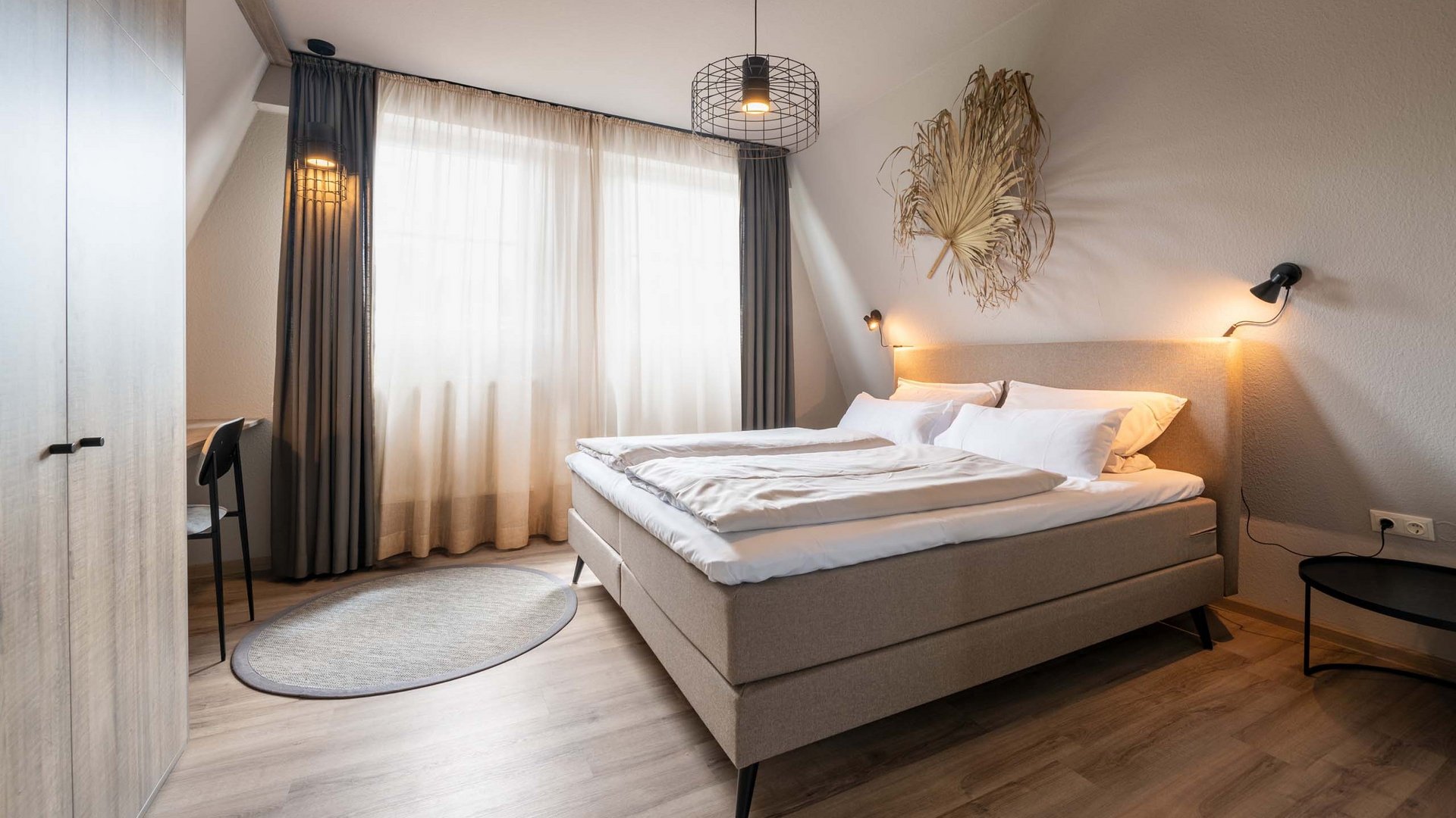 Seeblick: Ferienwohnungen Gronau Gemütliches Schlafzimmer mit Doppelbett und natürlicher Dekoration an der Wand
