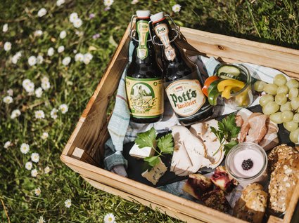 Restaurant Gronau: Seeblick Picnic basket with beers, cold cuts, cheese, grapes, and snacks on grass
