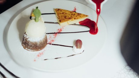 Appartementhotel Seeblick: Bildergalerie Dessertteller mit Eis, Kuchen und roter Sauce, die darüber gegossen wird