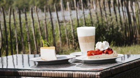 Appartementhotel Seeblick: Bildergalerie Taartpunten en latte macchiato op een tuintafel tussen de bomen