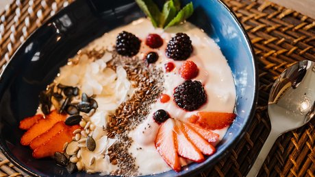 Appartementhotel Seeblick: Bildergalerie Schüssel mit Joghurt, Beeren, Samen und Nüssen auf Tisch mit Löffel