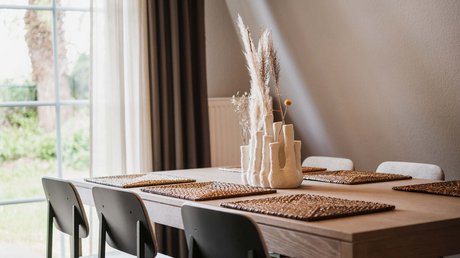 Appartementhotel Seeblick: Bildergalerie Moderner Esstisch mit braunen Platzsets und Keramikvase mit Trockenpflanzen