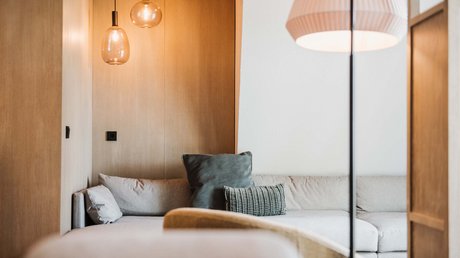 Appartementhotel Seeblick: Bildergalerie Moderner Wohnbereich mit Sofa, hängenden Lampen und Stehlampe
