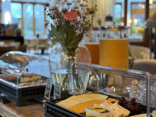 Breakfast at our restaurant Seeblick in Gronau Breakfast buffet with cheese, grapes, spread, and juice in a restaurant