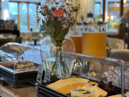 Restaurant Gronau: Seeblick Breakfast buffet with cheese, grapes, spread, and juice in a restaurant